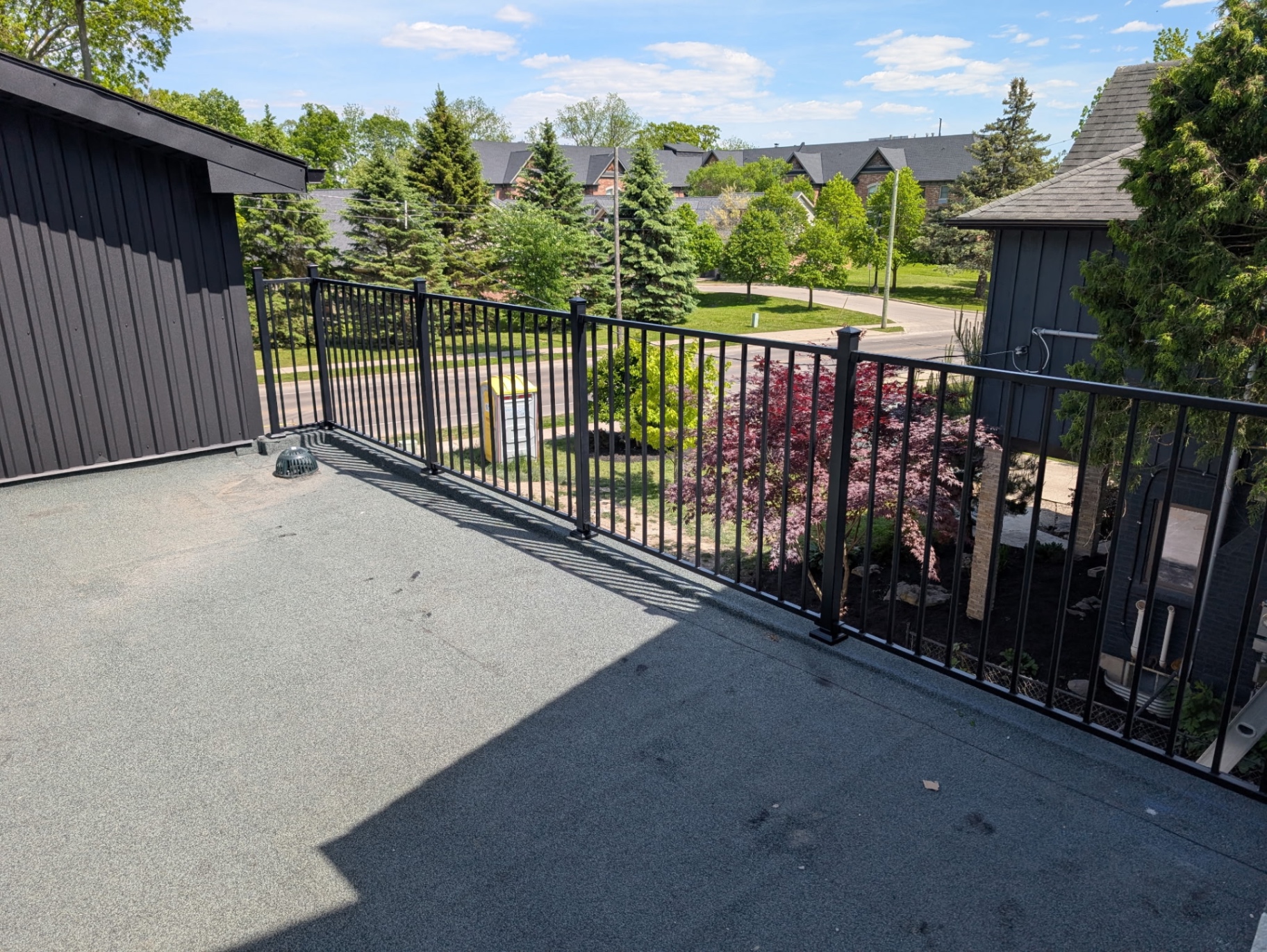 Black aluminum railing on flat roof deck